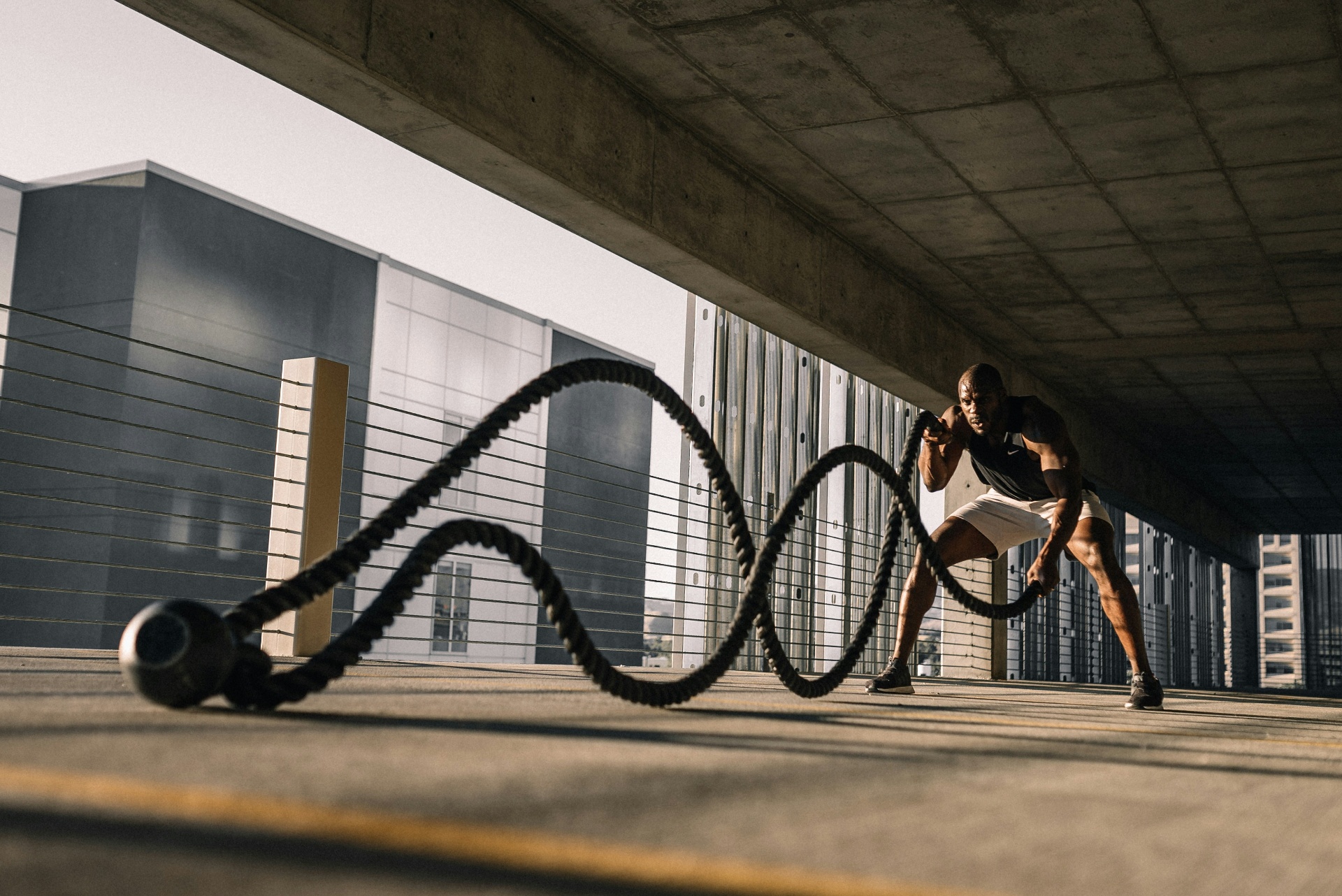 Athletic person training with battle ropes showcasing strength and fitness coaching
